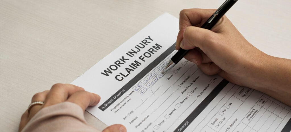 Workers-Compensation-Form Injury victim signing a work injury claim form.