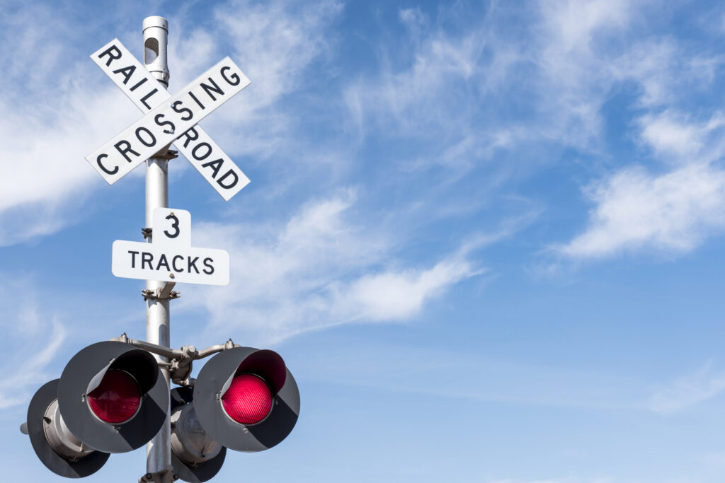 Blue skies with a railroad crossing sign.