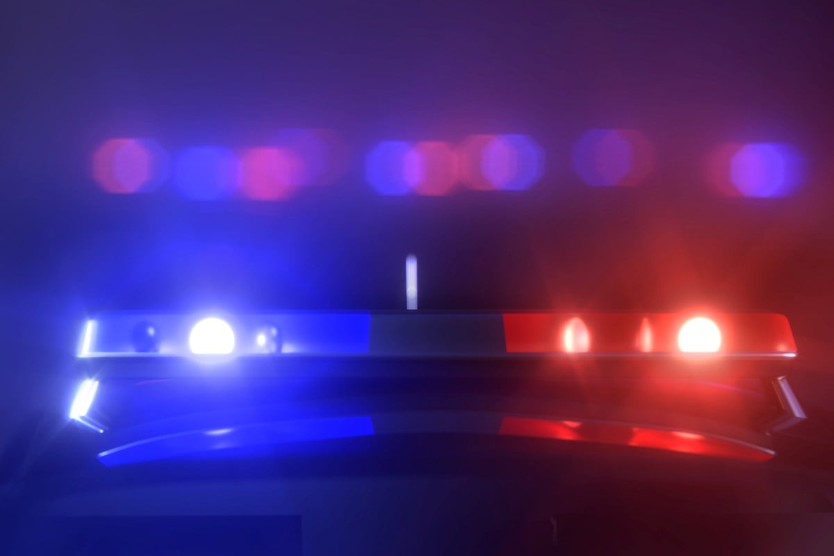 Police lights at a car accident scene at night.