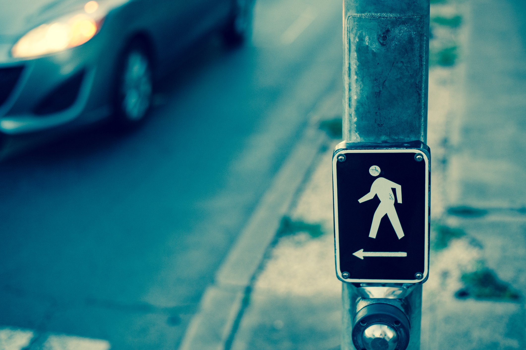 sign showing a pedestrian crosswalk button.